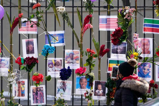 People look at a memorial for the victims of an apartment building fire near the site of the fire in the Bronx borough of New York.