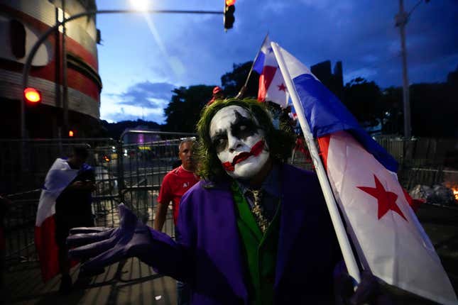 A demonstrator dressed as the comic book character The Joker, holds a Panamanian flag during a protest against a recently approved mining contract between the government and Canadian mining company First Quantum, in Panama City, Tuesday, Oct. 31, 2023. (AP Photo/Arnulfo Franco)