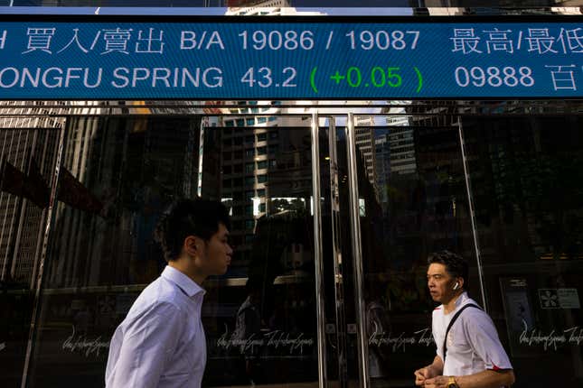 FILE - Pedestrians pass by the Hong Kong Stock Exchange electronic screen in Hong Kong, Thursday, June 29, 2023. China’s markets regulator on Friday, March 15, 2024, renewed its efforts to pep up the stock market, pledging to raise the quality of companies listed on domestic markets. (AP Photo/Louise Delmotte, File)