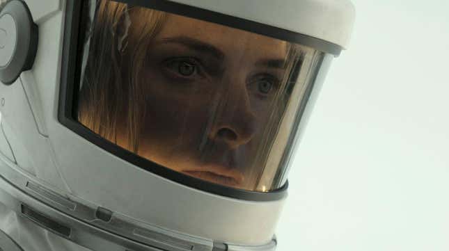 A woman appears in a space suit. 