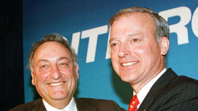 Sanford I. Weill (L), chief of the Travelers Group, and John S. Reed, chief of Citicorp, embrace at an April 6 press conference in New York