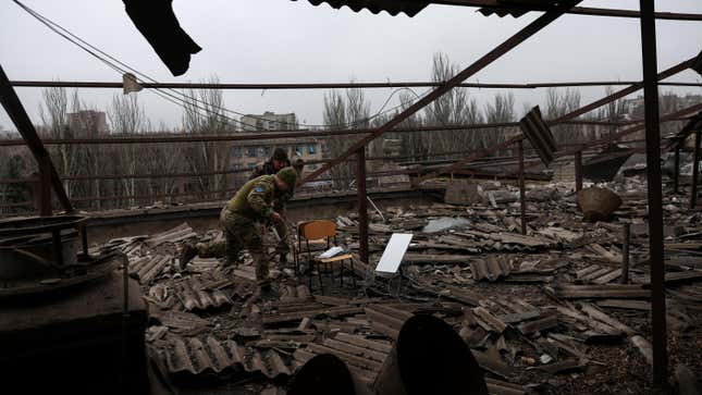 A Starlink satellite terminal is retrieved from a rooftop damaged by missile attacks.