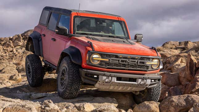 A photo of a Bronco Raptor driving over rocks. 
