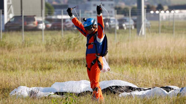 A person celebrates a successful parachute landing