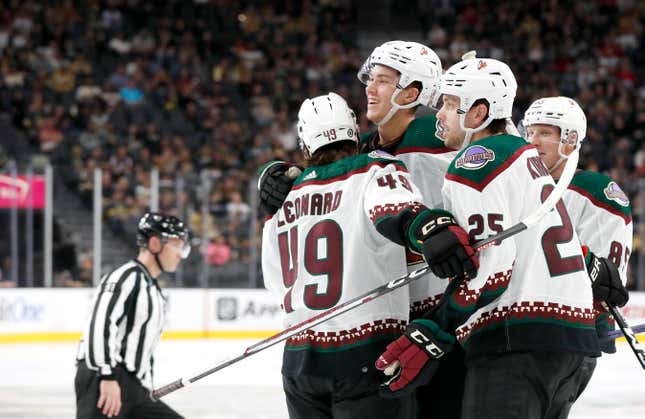 Arizona Coyotes defenseman Maveric Lamoureux, center, celebrates with forward John Leonard (49) and center Justin Kirkland (25) after scoring against the Vegas Golden Knights during the second period of a preseason NHL hockey game Friday, Sept. 29, 2023, in Las Vegas. (Steve Marcus/Las Vegas Sun via AP)