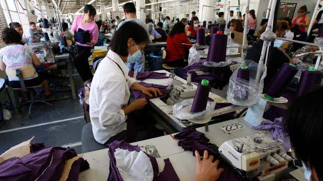 Trabalhadores de vestuário costurando em uma fábrica no centro de Los Angeles.