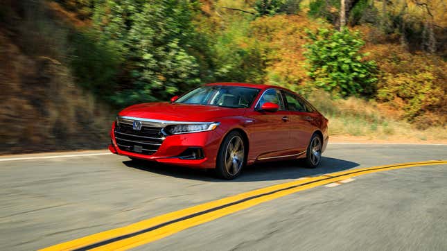 A red Honda Accord Hybrid on a two-lane road