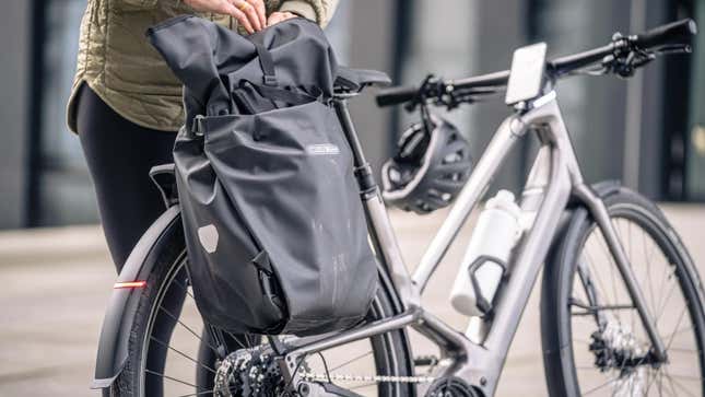 A photo of a person adjusting a bag on an electric bike. 