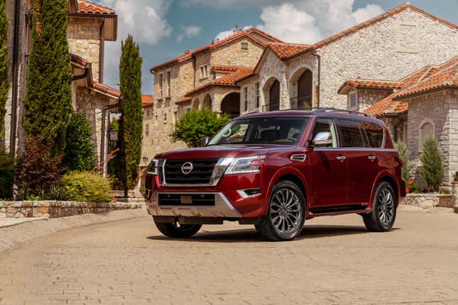 A red Nissan Armada parked in front of several buildings