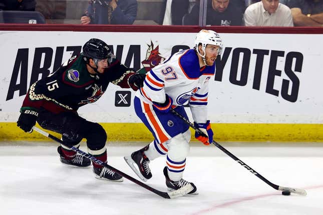 Apr 17, 2024; Tempe, Arizona, USA;  Edmonton Oilers center Connor McDavid (97) moves the puck against Arizona Coyotes center Alex Kerfoot (15) during the second period at Mullett Arena.