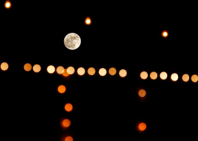 A supermoon rises as the colourful lights flicker in the foreground at a gurudwara, a Sikh temple, in Chandigarh, India.