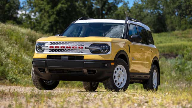 a light yellow and white ford bronco sport parked in a grassy field