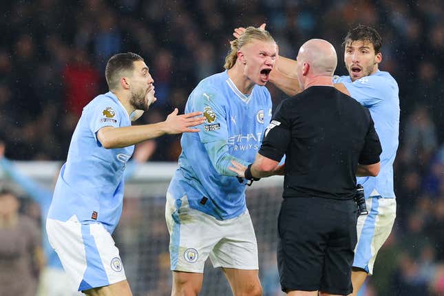 Referee Simon Hooper is surrounded by Erling Haaland, Mateo Kovacic, and Ruben Dias of Manchester City after he stopped the game to award Manchester City a free kick and deny Jack Grealish (not pictured) the chance to play on and have a goal scoring chance during the Premier League match between Manchester City and Tottenham Hotspur at Etihad Stadium on December 03, 2023 in Manchester, England.