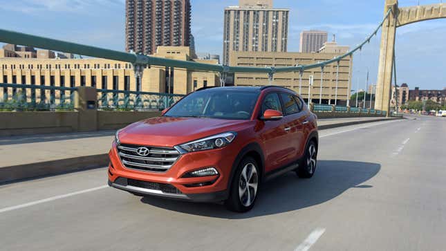 An orange Hyundai Tucson SUV drives across a bridge