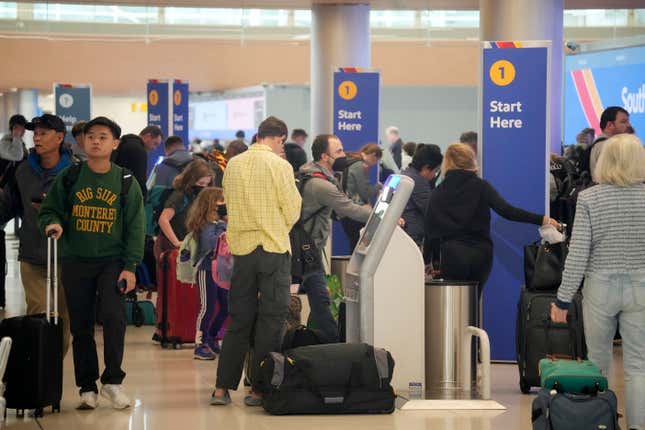 Travelers queue up to check in at self-service ticketing kiosks for Southwest Airlines in Denver International Airport on Monday, Nov. 20, 2023, in Denver. Despite inflation and memories of past holiday travel meltdowns, millions of people are expected to hit airports and highways in record numbers over the Thanksgiving Day break. (AP Photo/David Zalubowski)