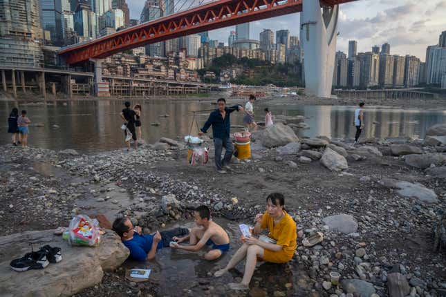 People sit in the riverbed of the Jialing on August 20.
