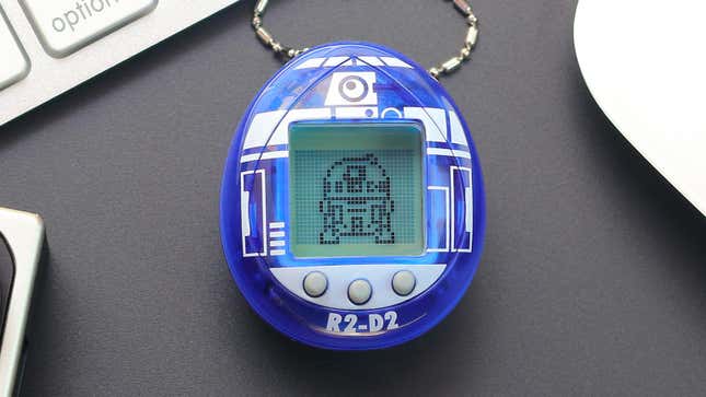 A close-up of the new blue and white R2-D2 branded Tamagotchi with the droid in pixels on its screen..