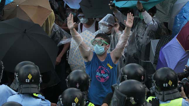 A student protester in Hong Kong tries to negotiate with riot police as they fire pepper spray in to the crowd on Sunday, Sept. 28, 2014.