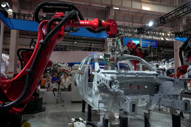 FILE - Visitors look at the robotic arms assembly a vehicle frame during the annual World Robot Conference at the Etrong International Exhibition and Convention Center in the outskirt of Beijing, on Aug. 17, 2023. China&#39;s factory activity in September recorded its first expansion in six month, an official survey said Saturday, Sept. 30, 2023, providing another sign that the world&#39;s second-largest economy is gradually improving following its post-pandemic malaise. (AP Photo/Andy Wong, File)