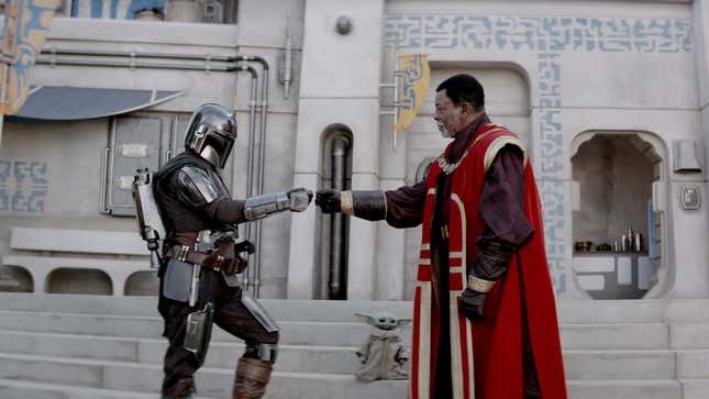 Two Star Wars characters bump fists together.