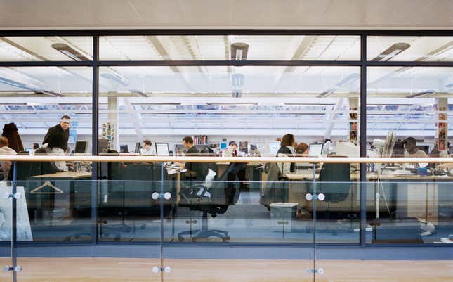 view through office window of people at their desks