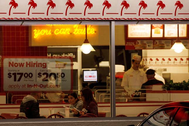 A "Now hiring" sign is displayed on the window of an IN-N-OUT fast food restaurant in Encinitas, California, U.S., May 9, 2022.