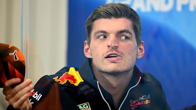 A photo of Max Verstappen pressing his face against glass. 