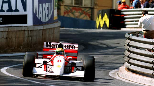 A white and orange McLaren MP4/8A racing in Monaco. 