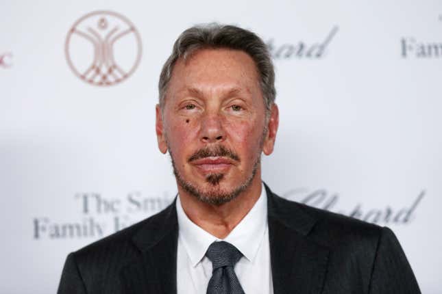 business new tamfitronics Larry Ellison looking at the camera with a small smile on his face, he is wearing a black suit jacket and tie with a white collared shirt