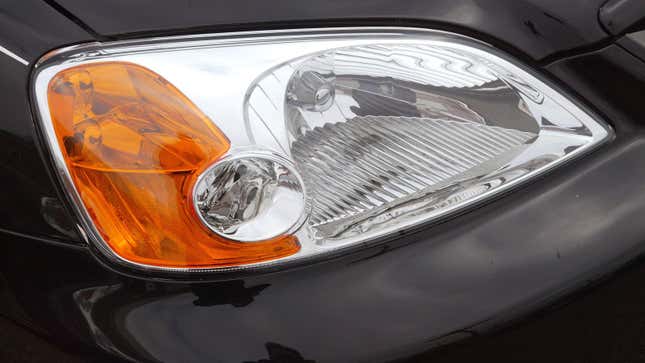 A close up of a front head lamp on a black car