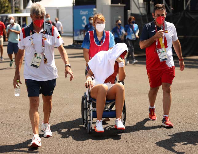  Paula Badosa of Team Spain is helped away from the court in a wheelchair after having to retire from her Women’s Singles Quarterfinal match against Marketa Vondrousova of Team Czech Republic on day five of the Tokyo 2020 Olympic Games at Ariake Tennis Park on July 28, 2021 in Tokyo, Japan. 