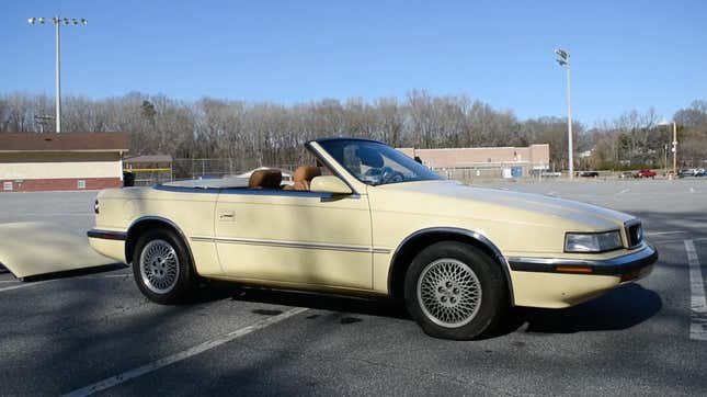 A photo of a beige Chrysler TC By Maserati in a parking lot.