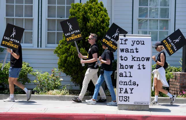 FILE - Picketers carry signs outside Amazon Studios in Culver City, Calif. on Monday, July 17, 2023. A tentative agreement between striking screenwriters and Hollywood studios offers some hope that the industry’s dual strikes may be over soon. (AP Photo/Chris Pizzello, File)