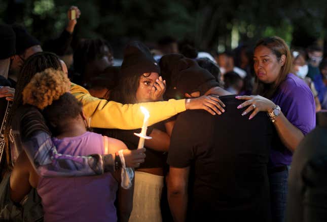  Mourners stand together as they hold a vigil in honor of slain 18-year-old Dwight “DJ” Grant on October 26, 2021 in Miramar, Florida. Miramar Police say that three teens planned and carried out the brutal murder of their Miramar High School classmate. 