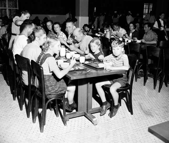 Children and adult immigrants detained at Ellis Island sit down to eat their noontime meal in New York City, June 12, 1947. 