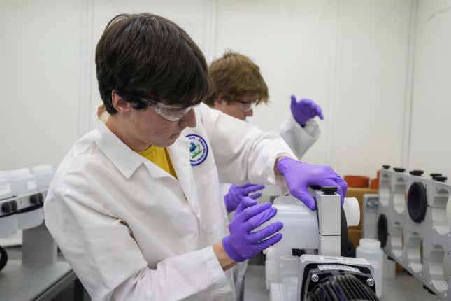 Jackson Quinn, foreground, places a bottle contains a PFAS water sample into a rotator, Wednesday, April 10, 2024, at a U.S. Environmental Protection Agency lab in Cincinnati. The Environmental Protection Agency on Wednesday announced its first-ever limits for several common types of PFAS, the so-called &quot;forever chemicals,&quot; in drinking water. (AP Photo/Joshua A. Bickel)