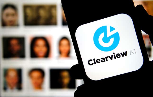 Clearview AI company logo on the smartphone screen held in hands with blurred faces in the background. Concept photo for face recognition software.