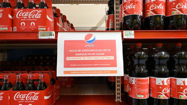 A sign on a Carrefour soda shelf reading in French: 'We no longer sell this brand due to unacceptable price increases'