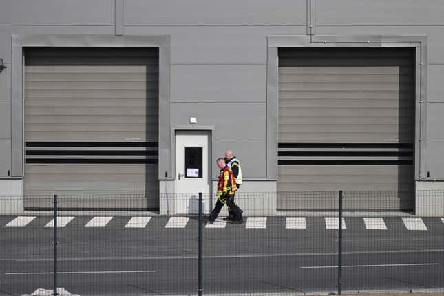 Fire department employees walk outside the Tesla car factory after production came to a standstill and workers were evacuated following a power outage, in Grünheide, Germany, Tuesday, March 5, 2024. (Sebastian Gollnow/dpa via AP)