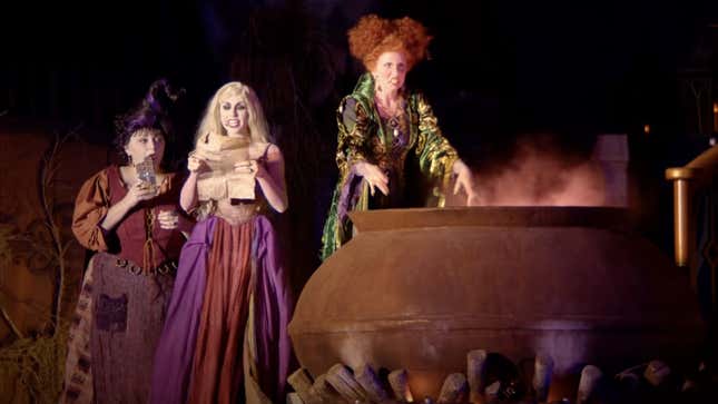 The Sanderson Sisters gather around a giant cauldron in a Disney Parks version of Hocus Pocus.