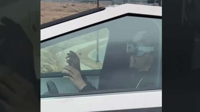 A man in a Tesla Cybertruck uses VR goggles while driving