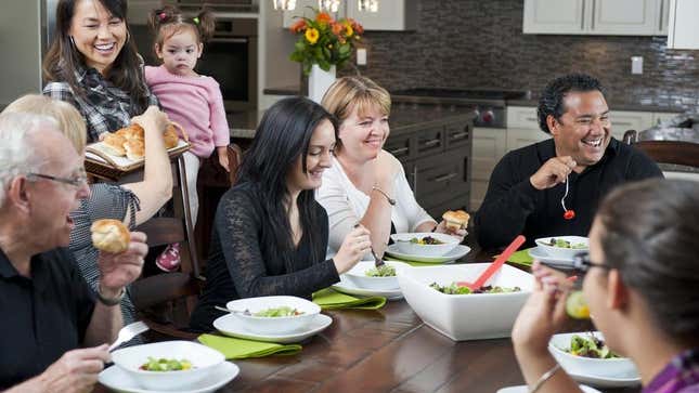 family gathered around dinner table laughing