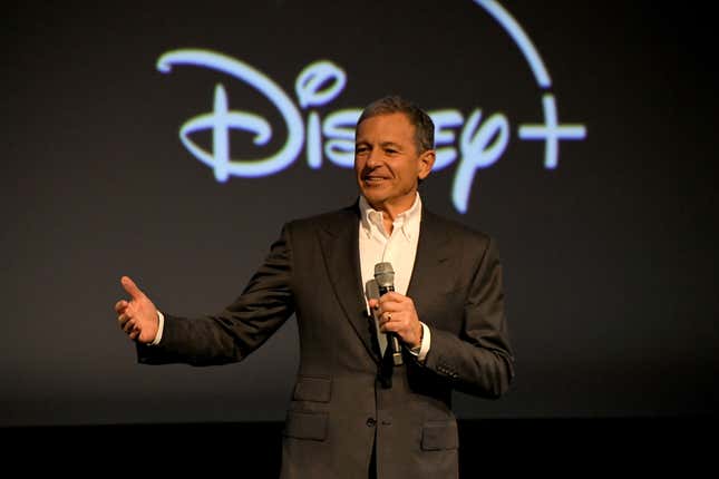 Disney CEO Bob Iger with a mic in front of the Disney logo