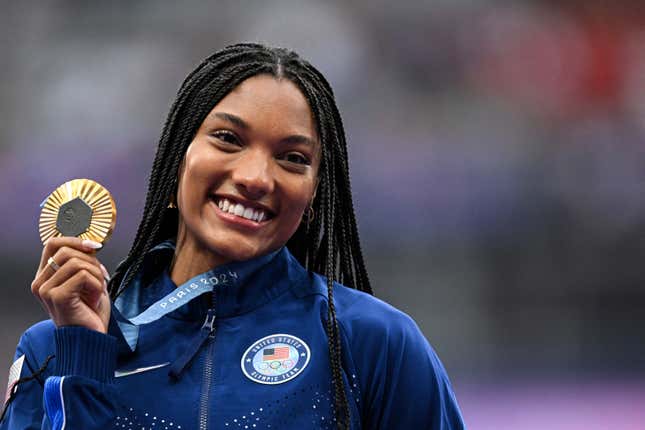 Tara Davis-Woodhall celebrates on the podium during the victory ceremony for the women’s long jump athletics event during the Paris 2024 Olympic Games at Stade de France in Saint-Denis, north of Paris, on August 9, 2024.