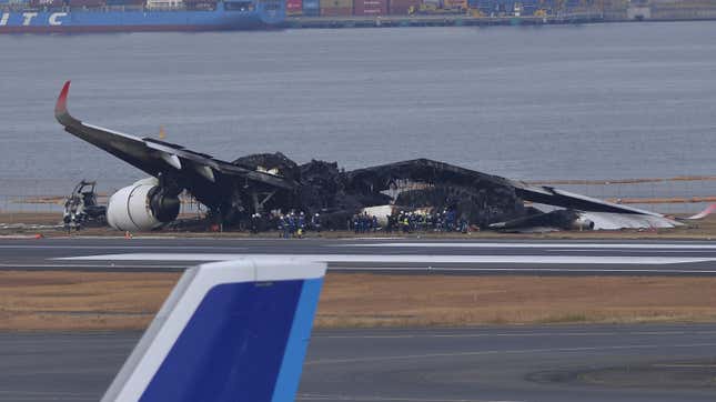 Police and officials inspect the wreckage of Japan Airlines aircraft JAL Flight 516 on the tarmac of Tokyo Haneda Airport on January 3, 2024, in Tokyo, Japan, a day after a collision, during landing, with an aircraft operated by the Japan Coast Guard.