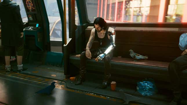Johnny Silverhand sits on the train staring at the ground with a sad look.