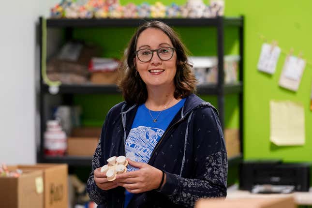 Jen Rose, a ceramic artist, poses with small garden installations that capture water to feed pollinators at her company, Bee Cups, in Dallas, Friday, Nov. 17, 2023. Small businesses say loans are harder to get than ever, as banks tighten lending standards and interest rates increase. Rose had a hard time finding a loan to expand her successful business. (AP Photo/LM Otero)