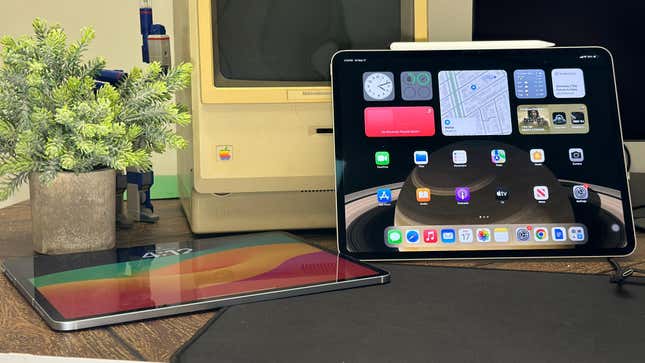 A 2024 iPad Air and iPad Pro sitting side by side showing the lock screen and apps next to an old Macintosh