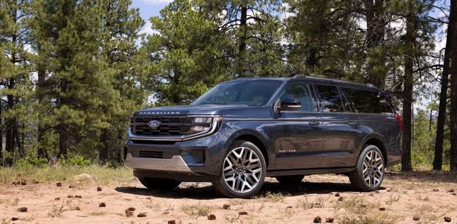 A photo of a dark blue Expedition Max Platinum parked in a forest