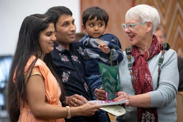 Yogeshkumar Patel, second left, holds his child as he and his wife, Divya, left, originally from India, participate in a citizenship ceremony in Rotorua, New Zealand, on July 27, 2021. New Zealand&#39;s annual net immigration has soared to a record 110,000 as a post-pandemic surge of movement continues, according to figures released Wednesday, Oct. 11, 2023. (Andrew Warner/The Daily Post via AP)